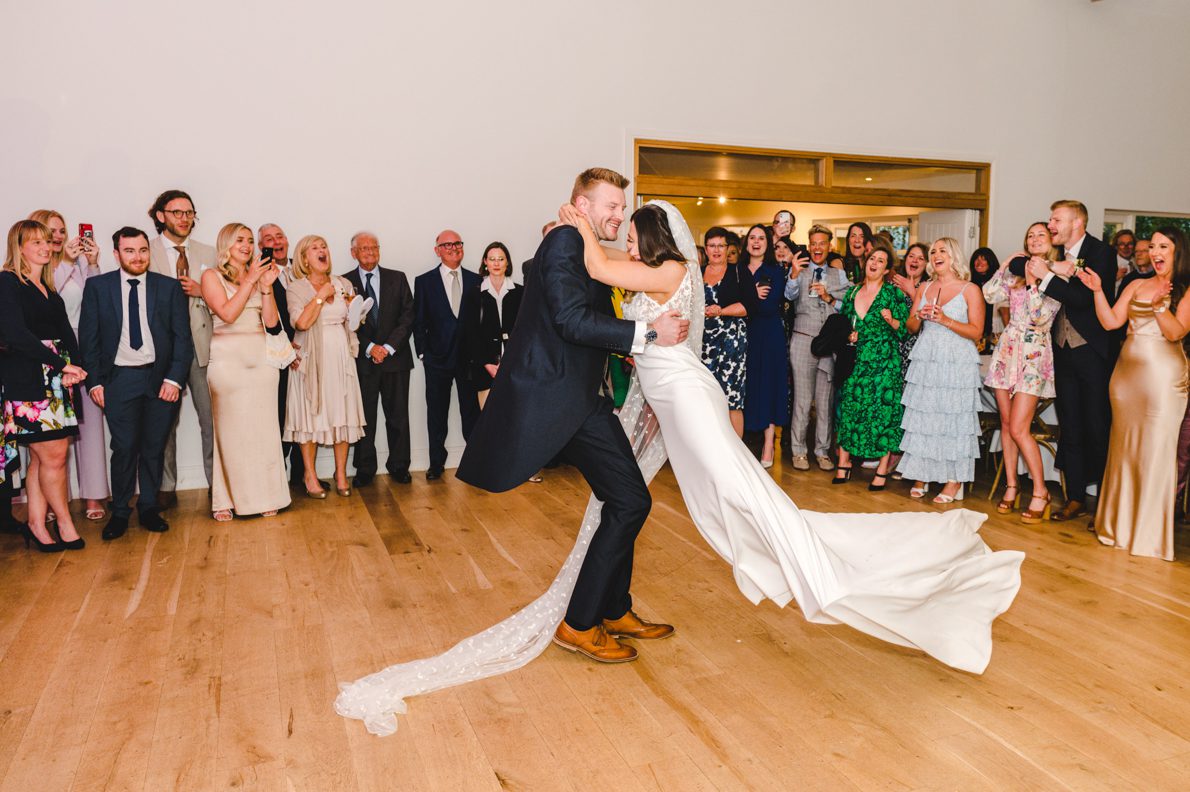 a bride swinging his groom around on the dnacefloor